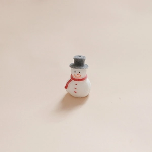 Détail d'un mini bonhomme de neige floqué avec chapeau gris et écharpe rouge de Noël