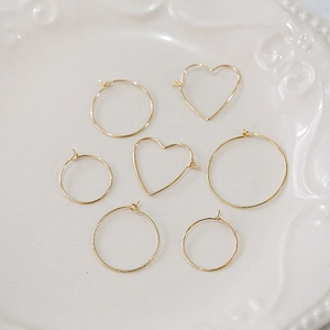 Detailed view of assorted 14k gold plated heart and round textured hoop earring components