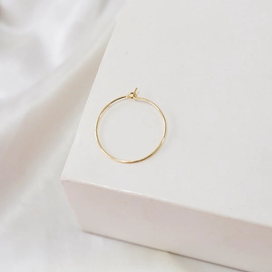 Detail of 14K gold plated circular hoop earring wire with simple hook clasp on white background