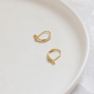 Macro detail of gold-plated lever-back earring hooks for DIY jewelry making accessories