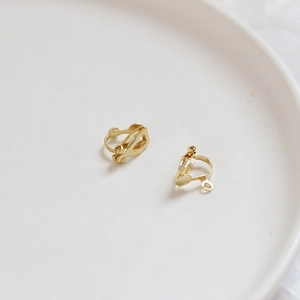 Detail of 14k gold-plated DIY ear clip converters with hanging loops on ceramic tray