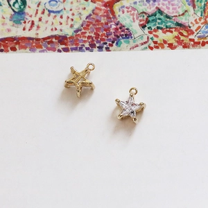Macro view of 18k gold-plated star charms with sparkling cubic zirconia for DIY jewelry