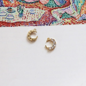 Macro view of 18k gold-plated crescent moon pendants with set cubic zirconia detail