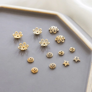 Vista detallada de capuchones de flores y cuentas espaciadoras bañadas en oro de 14k
