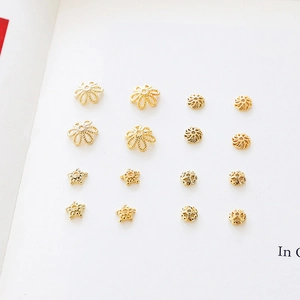 Vista detallada de capuchones de flores y cuentas espaciadoras bañadas en oro de 18K