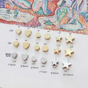 Foto macro de colgantes estrella y corazón en oro 14K y platino para joyería DIY