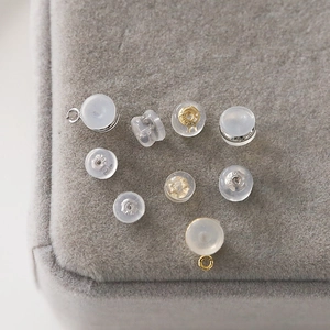 Macro detail of clear silicone earring backs with silver and gold plated metal inserts