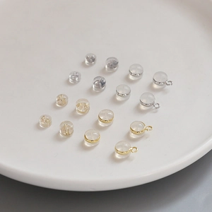 Close-up of gold and silver plated silicone earring backings on a white ceramic tray