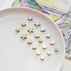 Macro detail of 14k gold plated star and heart beads for DIY jewelry making
