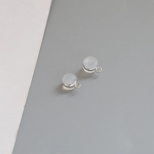 Macro shot of silver plated round white stone charms with metal loop for DIY jewelry