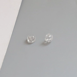 Macro detail of transparent silicone earring backs with silver-plated copper inner core