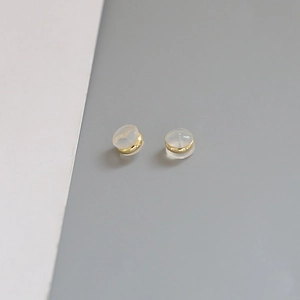Macro detail of gold plated earring studs with transparent silicone invisible backings