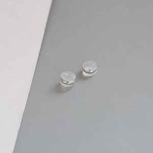 Macro shot of silver-plated copper ear nuts with clear anti-slip silicone pads