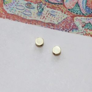 Macro detail of 14k gold plated round circular beads with side holes for DIY jewelry