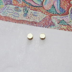 Detailed view of two polished gold circular spacer beads with side holes for DIY jewelry