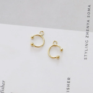 Detail showing gold C-shaped ear cuffs with small hanging loops for DIY jewelry making
