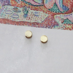 Close-up of gold-plated flat round beads with side holes for DIY jewelry making