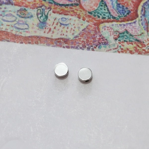 Close-up of round silver flat beads with side holes for DIY jewelry making and bracelets