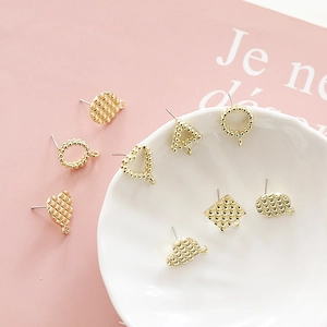 Gedetailleerde weergave van gouden geometrische DIY-oorsieraden met ruitvormige textuur
