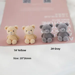 Detail of 20x26mm flocked teddy bear charms in yellow and grey with knitted texture