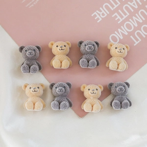 Detail view of 8 miniature flocked teddy bear charms in grey and beige colors