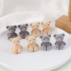 Detailed view of eight mini teddy bear resin charms with flocking texture in a white tray