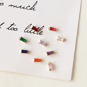 Primer plano de colgantes rectangulares de circón multicolor bañados en oro para joyas