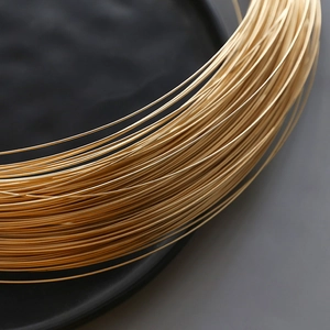 Makro-Detail von 14k goldgefülltem Schmuckdraht mit glänzender Metallstruktur und Glanz