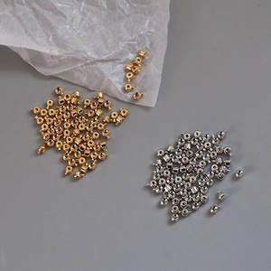 Gros plan de perles à écraser en plaqué or 18k dorées et argentées pour bracelets DIY