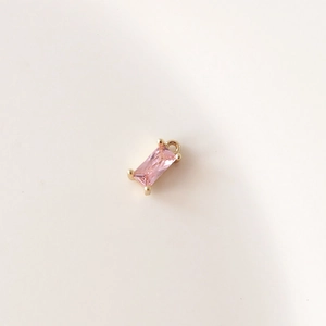 Primer plano detallado de un colgante de circón rosa rectangular con engaste chapado en oro