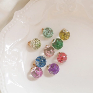 Nine clear glass ball charms with colorful dried flowers and gold metal loops