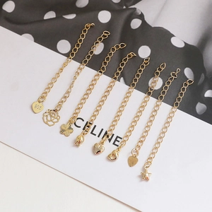 Close-up of 14K gold plated jewelry extension chains with heart and star charms