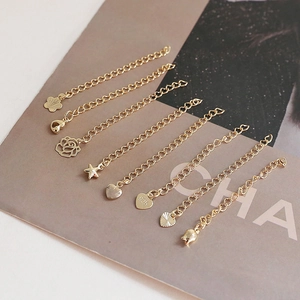 Close-up of 14k gold-plated extension chains with star and heart shape pendants