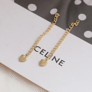 Detail of 14k gold plated heart drop earrings on decorative props and jewelry cards
