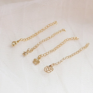 14K gold-plated jewelry extension chains with heart, star, and flower charm pendants