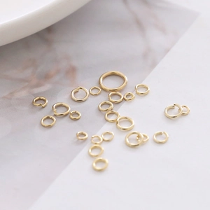 Vista macro di anellini aperti placcati in oro 14k in varie misure per gioielli fai-da-te