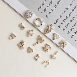 Luxury gold-plated zircon nail art charms with pearls and geometric shapes on a magazine