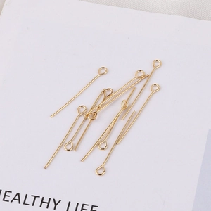 Detalle macro de alfileres de ojo chapados en oro de 18k para creación de joyas y aretes