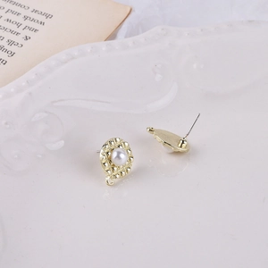 Detail von goldenen geometrischen Ohrringen mit Gitterstruktur und Perle für DIY-Schmuck