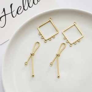 Detailed macro view of gold hollow rhombus charms and twisted spiral pendants for DIY jewelry