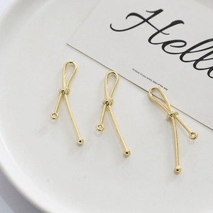 Detail of gold-plated hollow diamond knot pendants for DIY earring jewelry making
