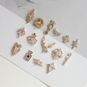 Detailed view of 15 gold plated swan and geometric charms with cubic zirconia inlay
