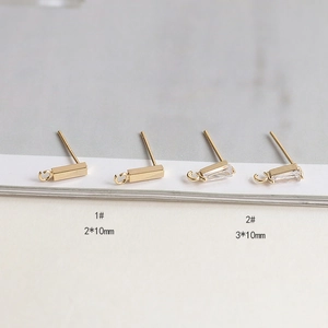 Vue macro de clous d'oreilles dorés avec zircons et petits anneaux de suspension