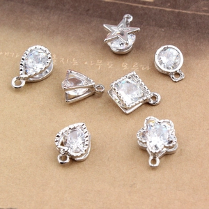 Detailed view of silver metal pendants with inlaid cubic zirconia in multiple geometric shapes