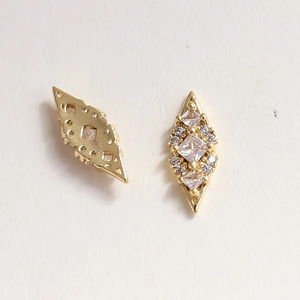 Detail of swan-shaped nail charms showing the front cubic zirconia and the back hollow structure