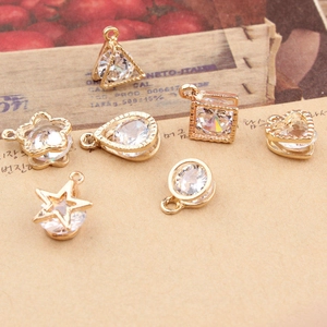 Macro detail of gold-plated geometric pendants with embedded zircons for DIY jewelry