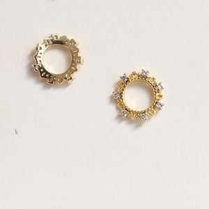 Detailed view of hollow gold-plated nail art charms with embedded sparkling zircons