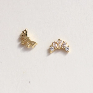 Macro detail of golden crown-shaped nail art charms with micro-inlaid zircon crystals