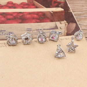 Detailed close-up of mixed geometric silver pendants with inlaid clear zircons for DIY jewelry