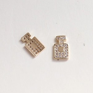 Macro view of gold perfume bottle charms with crystal rhinestones for nail art DIY